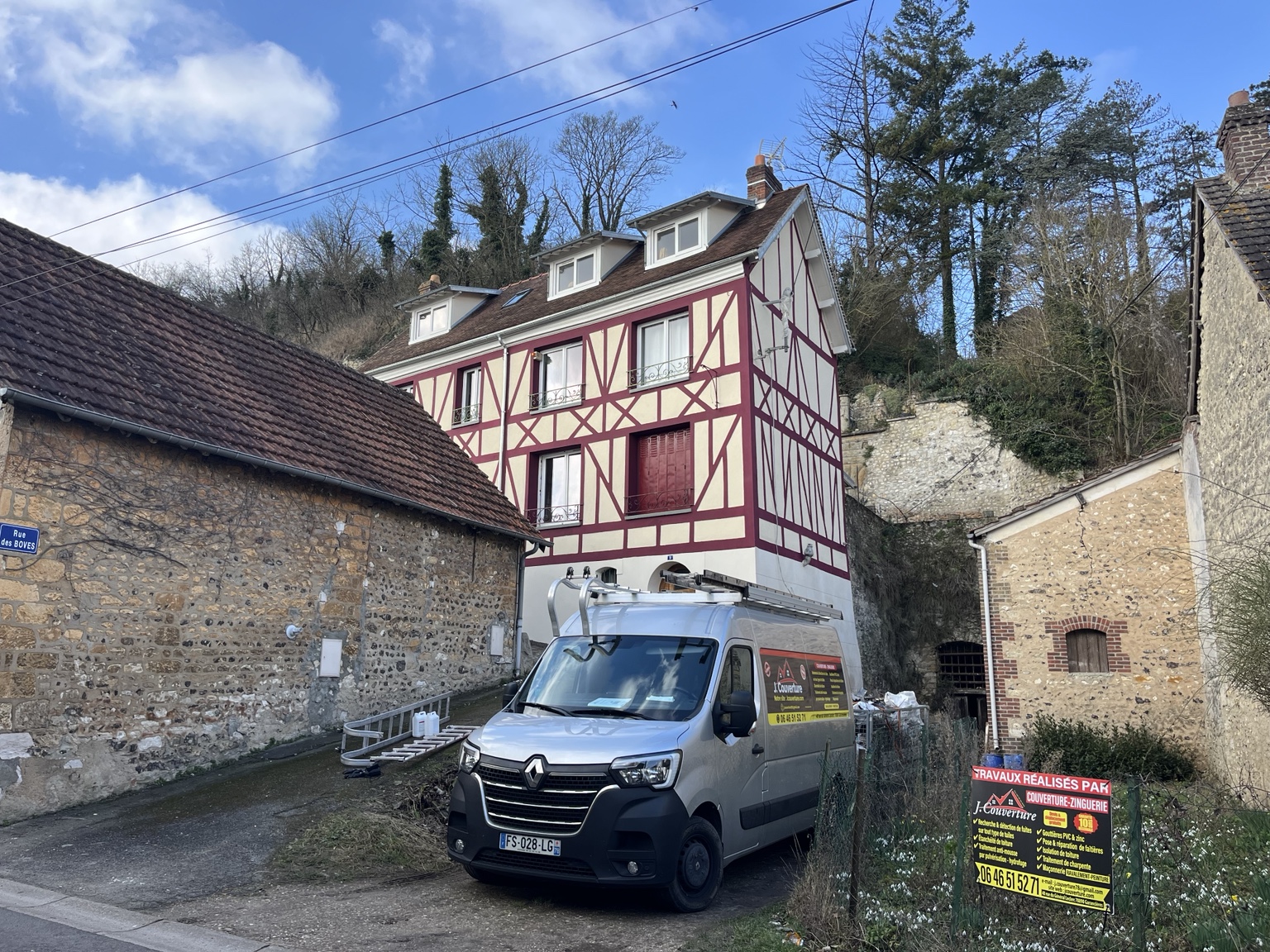 Véhicule et matériel J. Couverture devant une maison à lucarnes